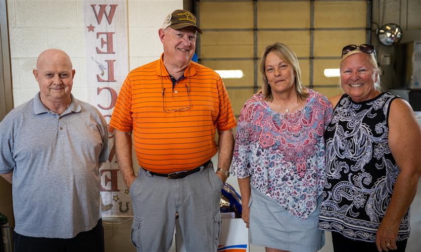 Four retiring bus drivers smile